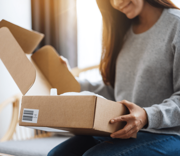 a young woman opening a postal parcel box at home